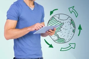 Homem usando um tablet, com um gráfico ilustrativo de economia circular, representando o planeta Terra com setas e elementos de reciclagem