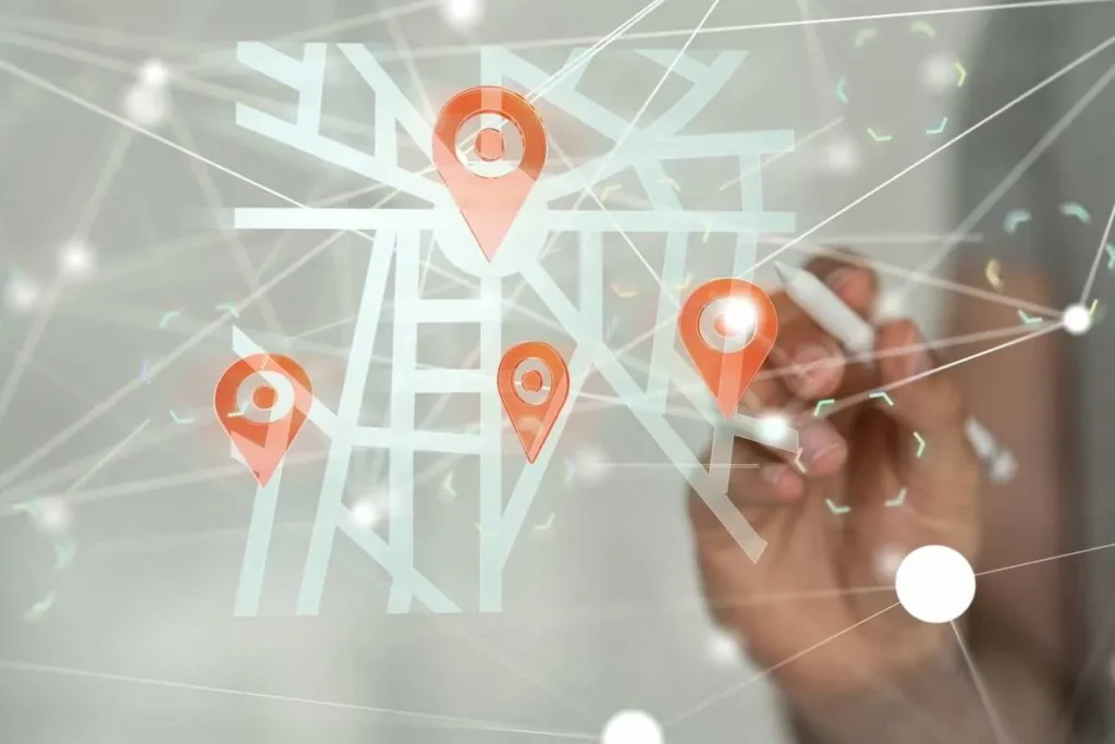 Mão de uma pessoa interagindo com um mapa digital com marcadores de localização e rotas, representando a roteirização e otimização de entregas com tecnologia.