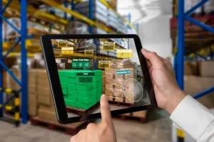 Tablet com Realidade Aumentada (RA) sendo usado em um armazém, exibindo informações de estoque e tempo de separação (Order Pick Time), impulsionado por análise de Big Data.