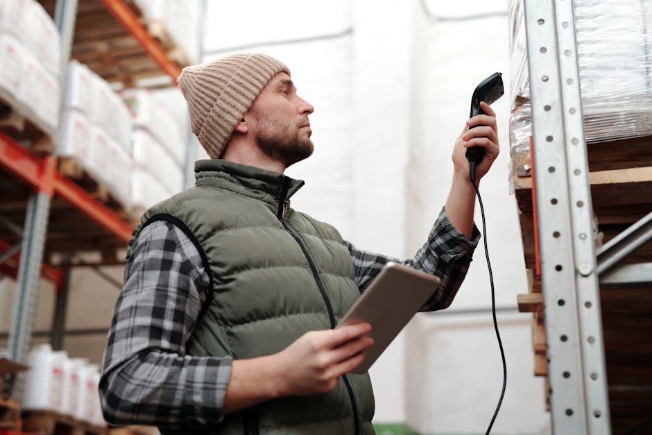 Operador usando scanner IoT e tablet para monitoramento de cargas em armazém logístico