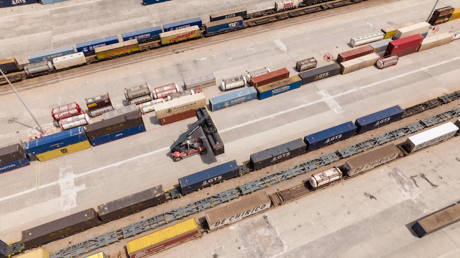 Vista aérea de hub logístico com containers empilhados e equipamentos de transbordo multimodal