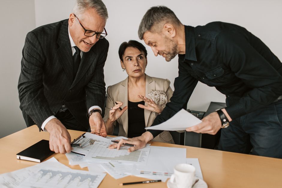 Equipe de gestão logística analisando indicadores e documentos de SLA em reunião